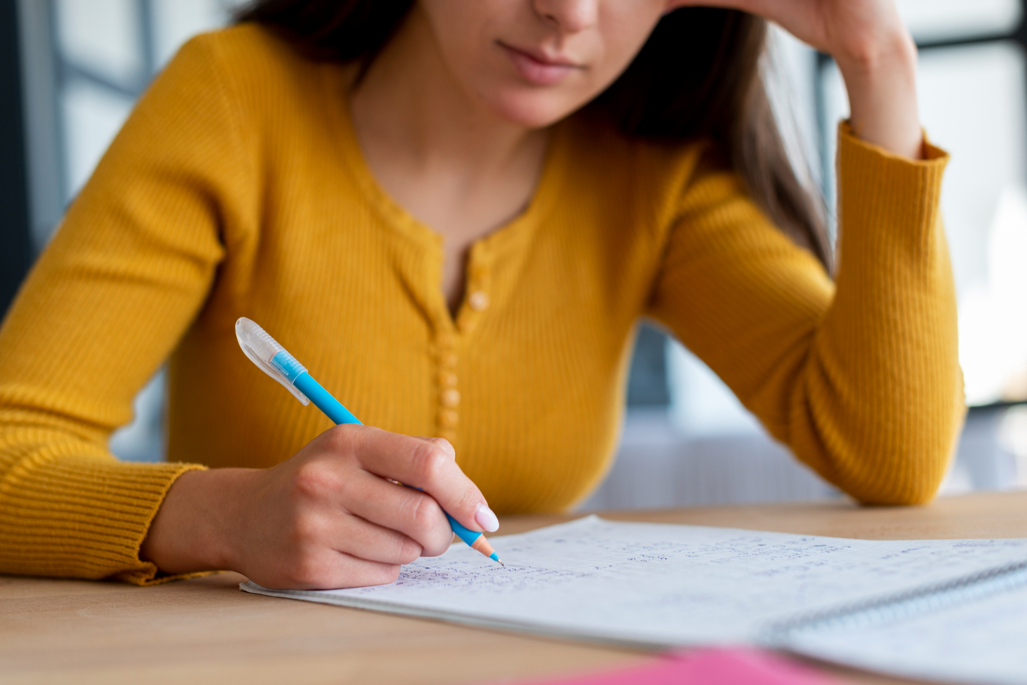 Chica realizando una evaluación en papel y boli.